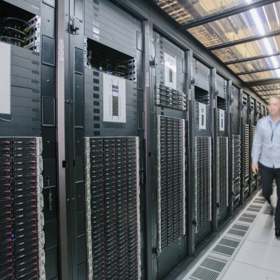 A man walks along a corridor in a data centre